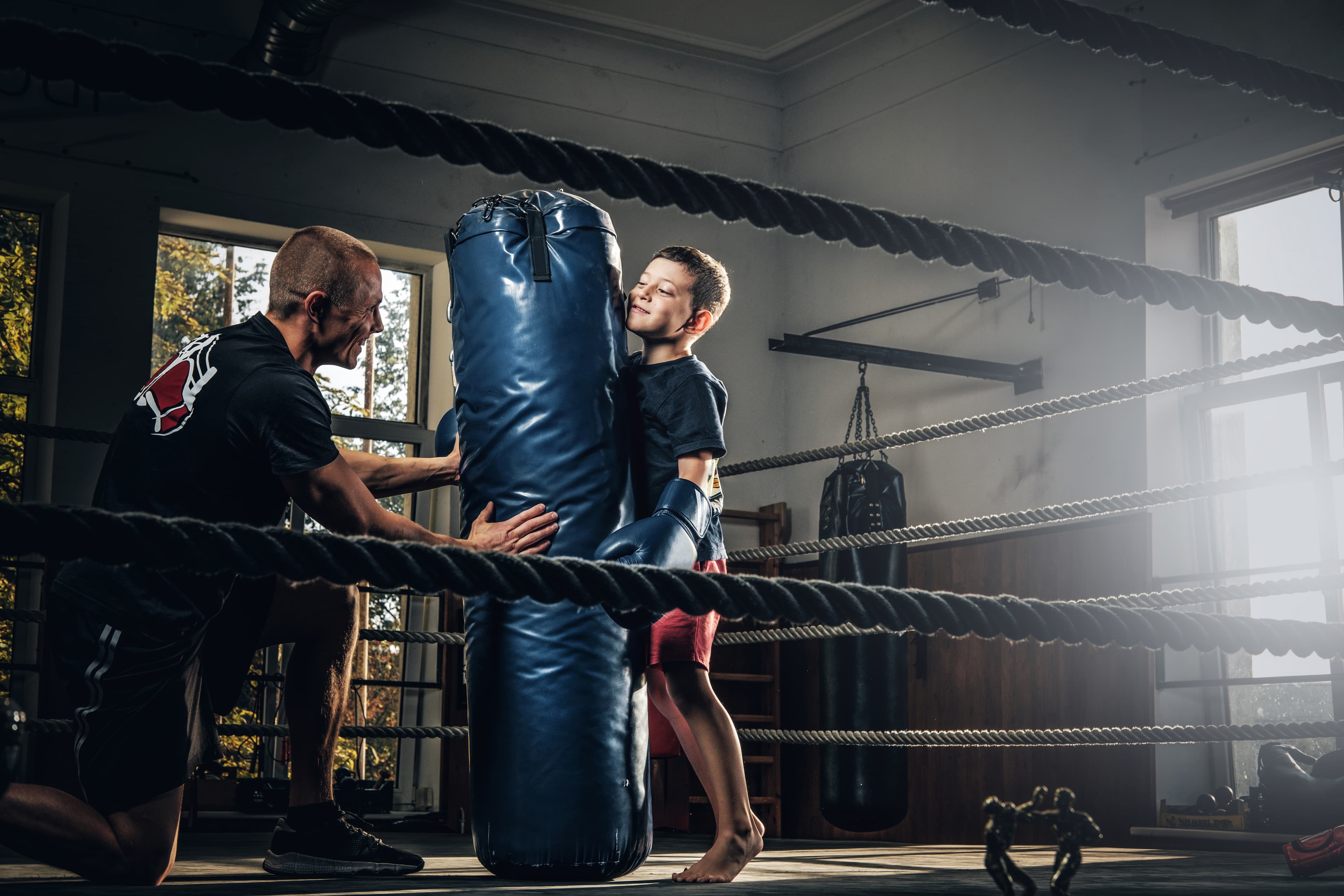 Entrenador con un joven boxeador en el saco, AG Boxeo